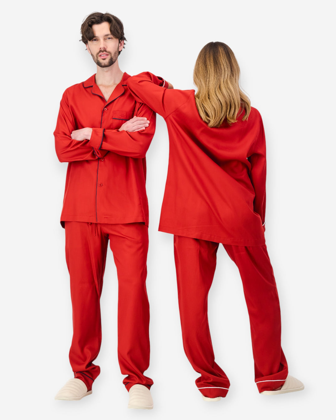 Two people wearing red tencel pyjama sets on a white background