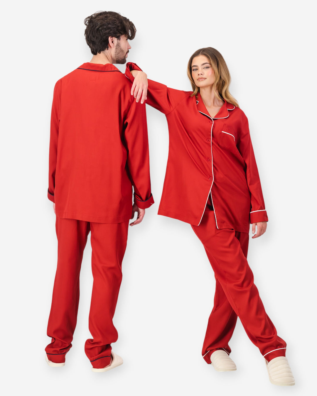 Two people wearing red tencel pyjama sets on a white background