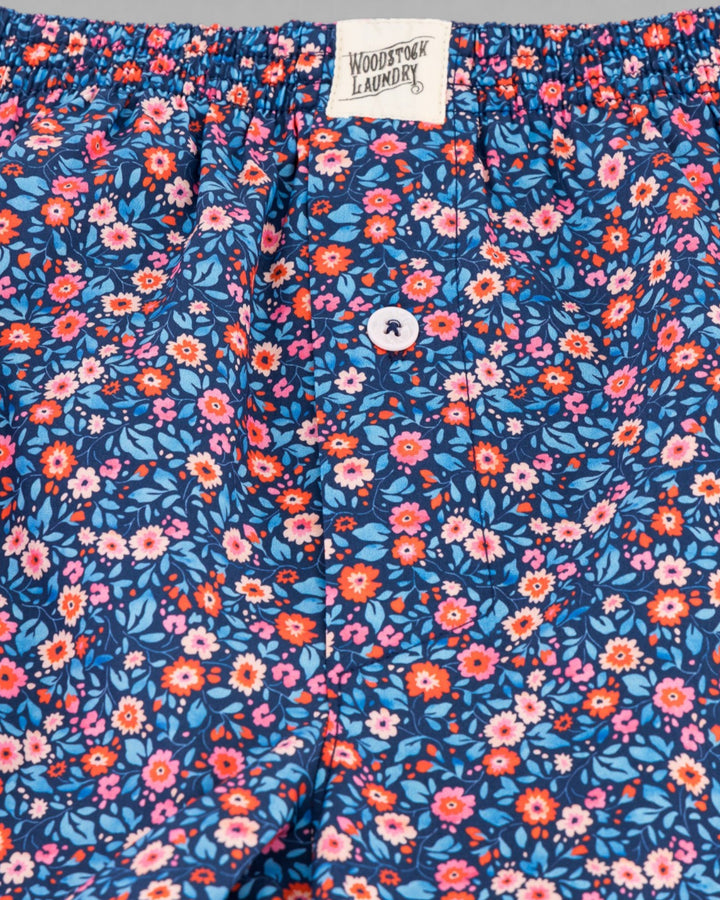 Macro view of the Dipsy floral pattern with pink and orange blossoms on a blue background.