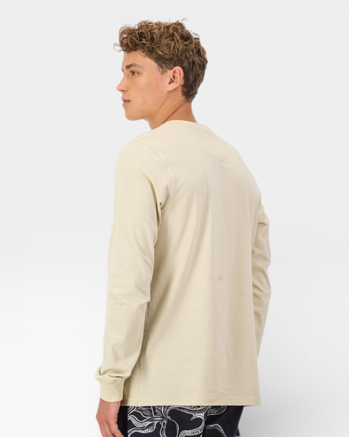 Man wearing a beige long-sleeve shirt on a white background