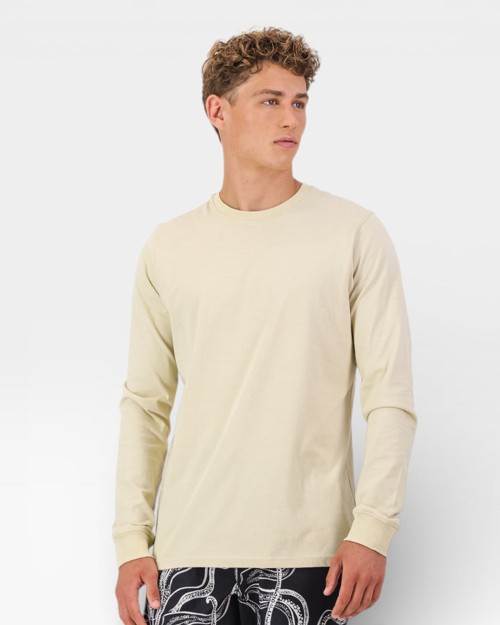 Man wearing a beige long-sleeve shirt against a white background