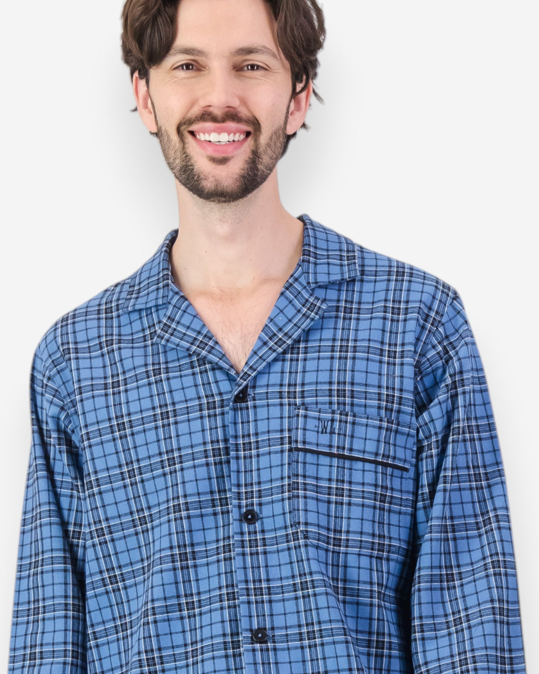 Man wearing a blue plaid flannel pyjama shirt against a white background