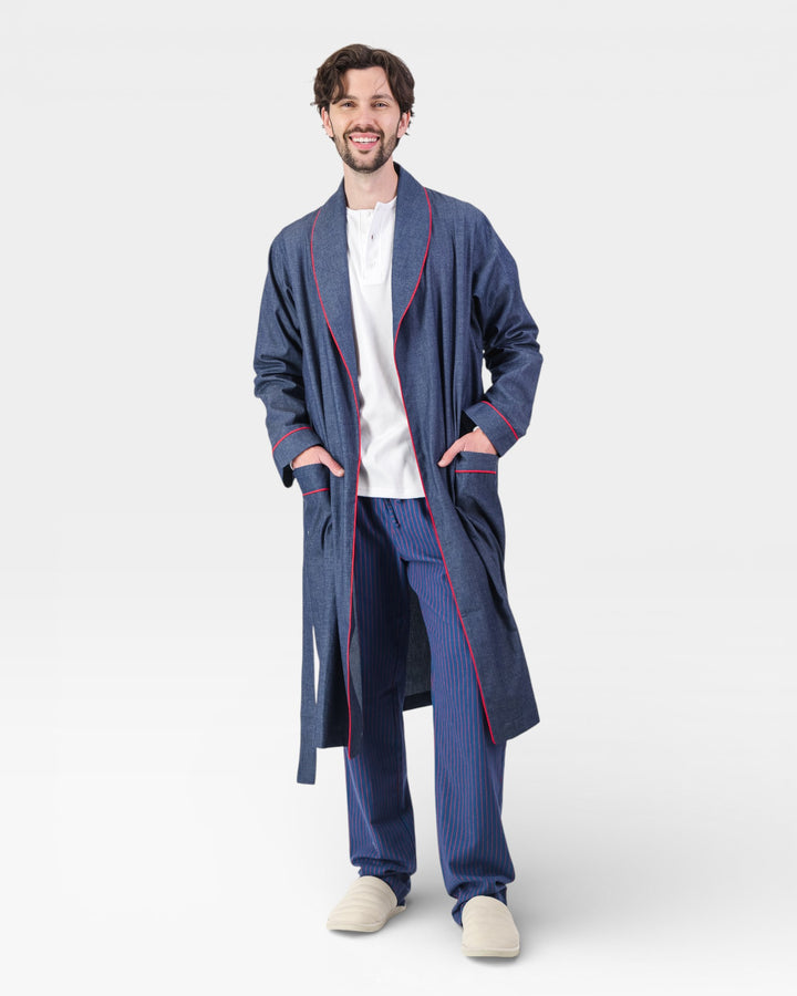Man wearing a blue dressing gown with red piping on a white background