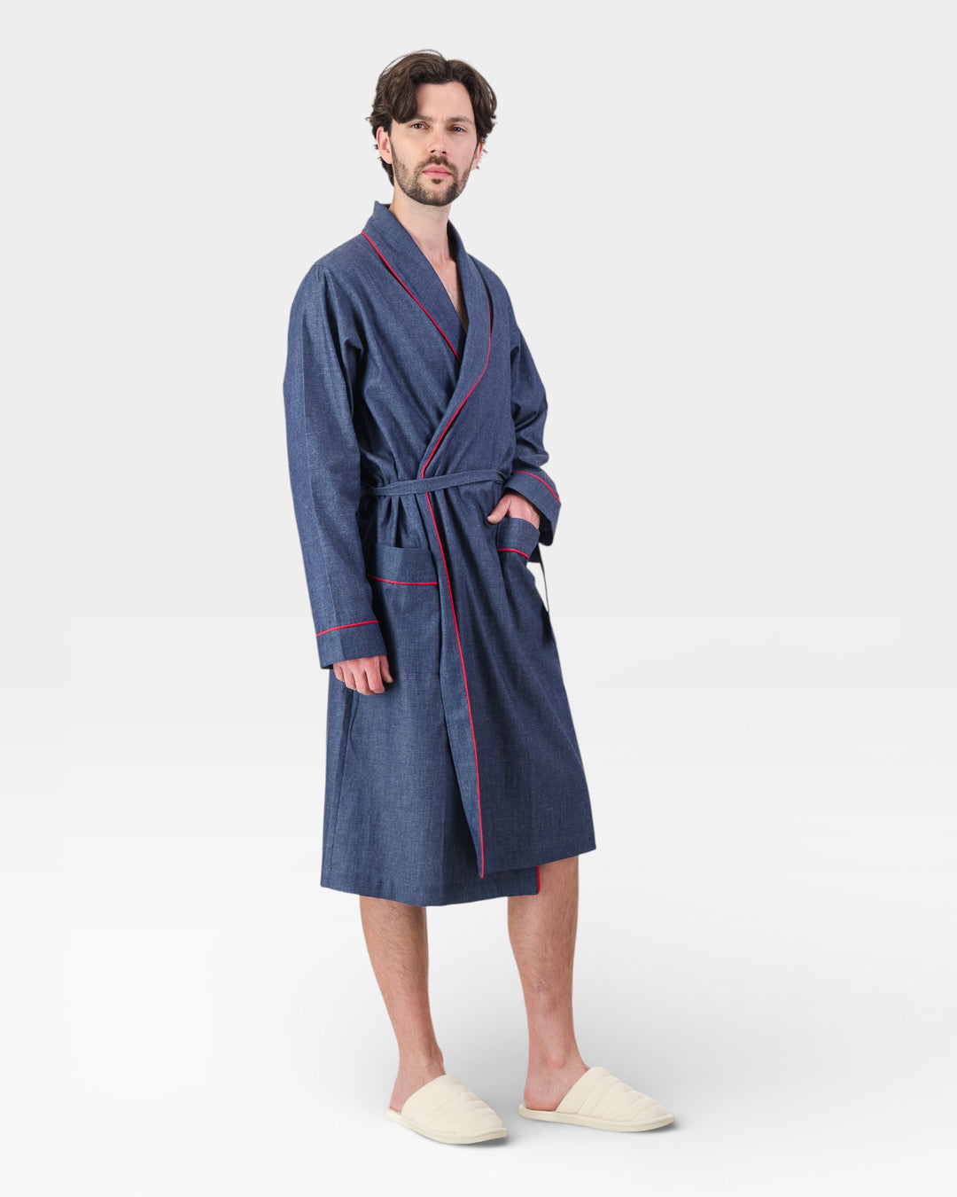 Man wearing a blue dressing gown with red piping on a white background