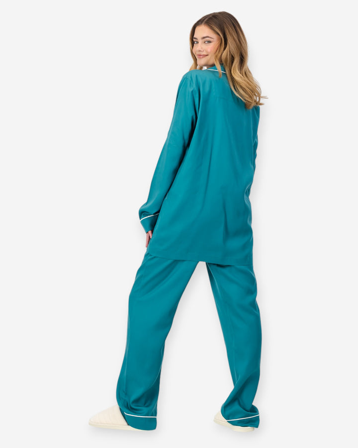 Person wearing a teal pyjama set on a white background